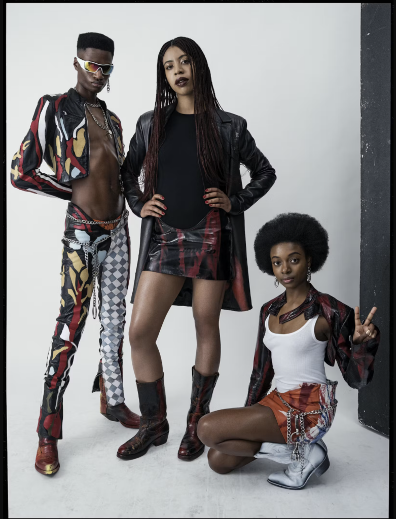 image of Nigerian British Fashion Designer Mowaloa Ogunlesi. with a model to her left and right.